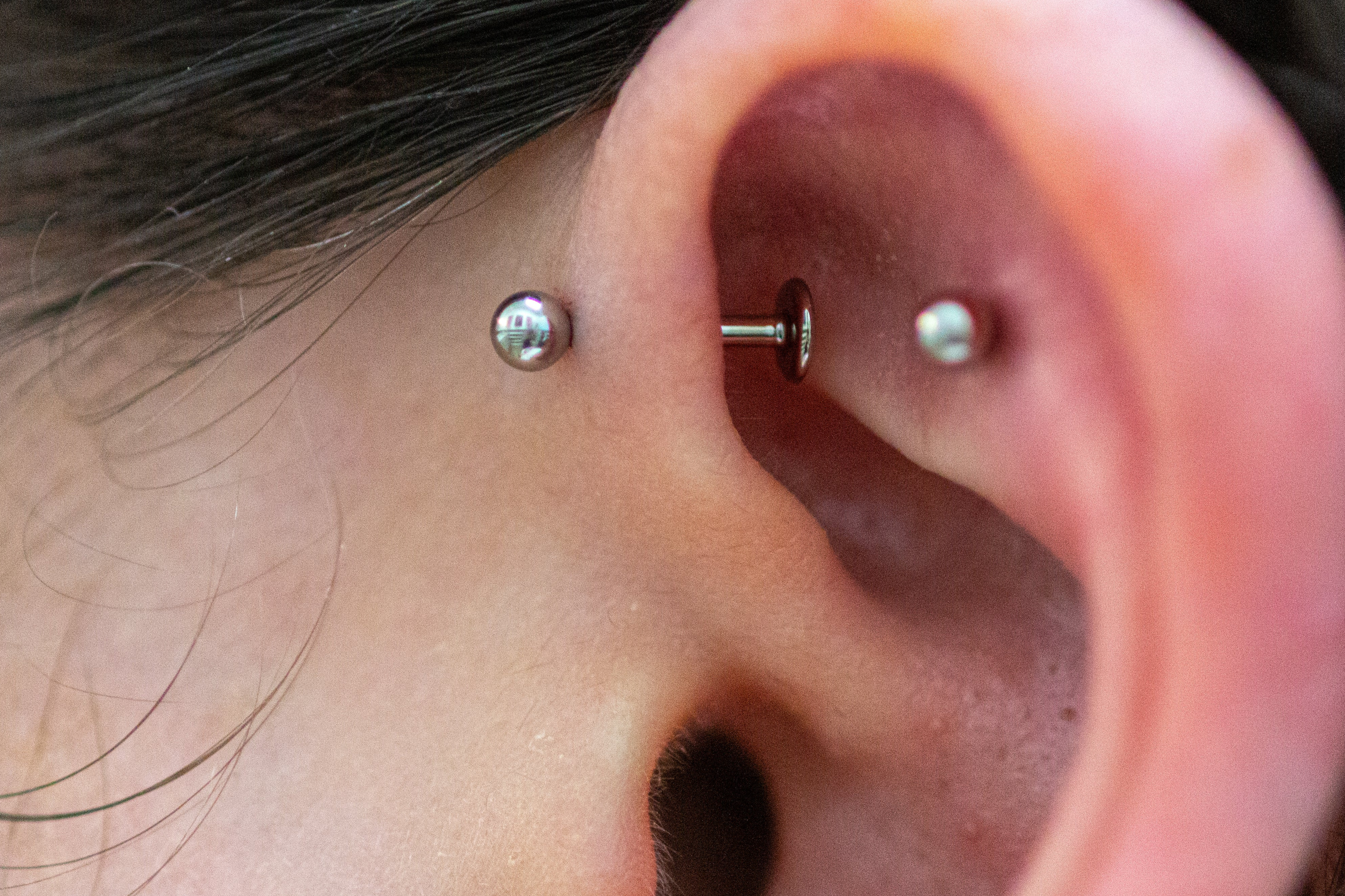 Picture of a forward helix piercing adorned with a titanium threadless labret post & ball.